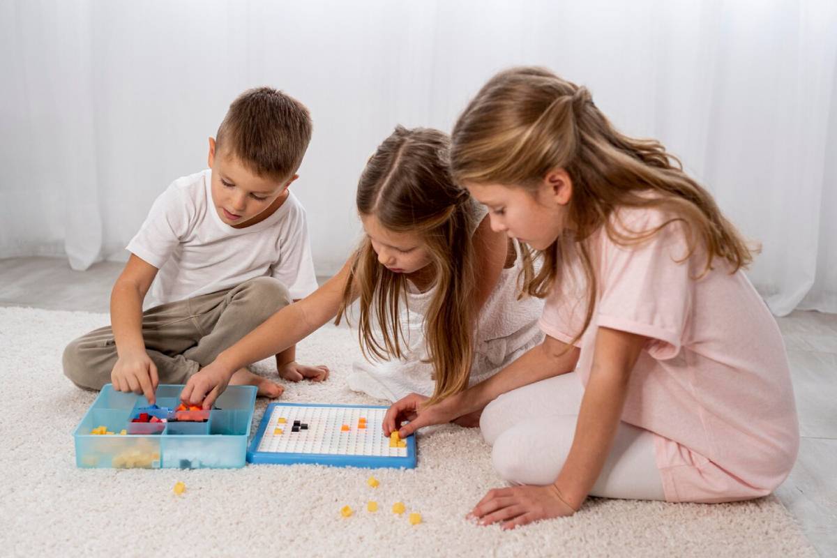 Three children playing a board game on a white carpet indoors.