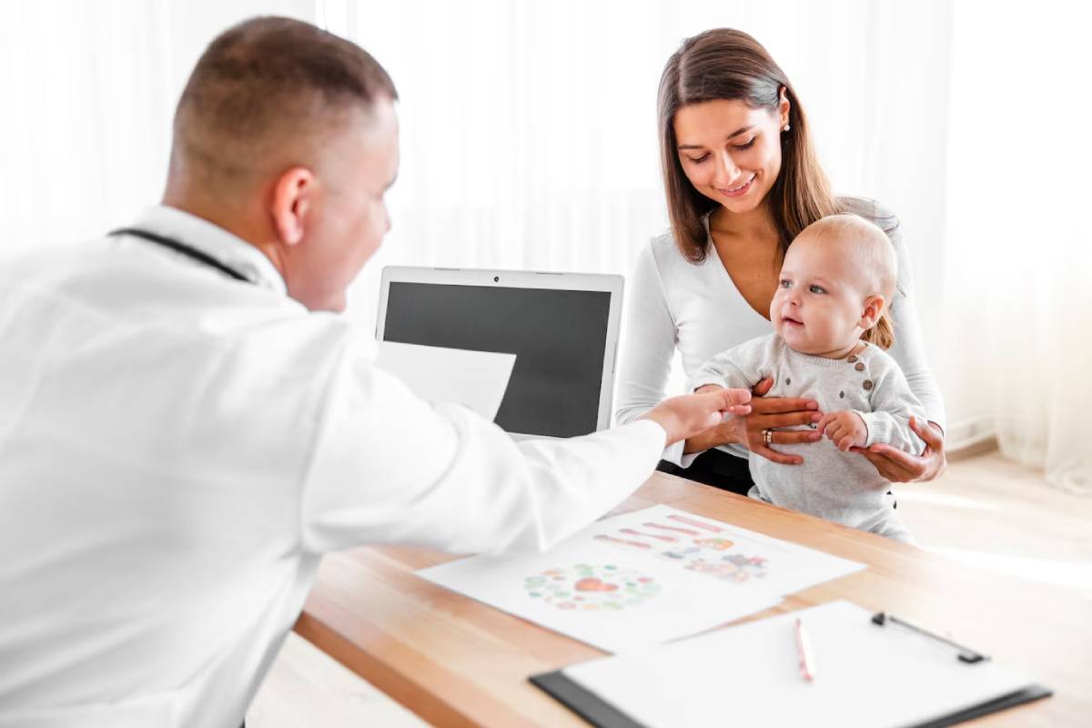 Father multitasking with laptop, holding baby, 
