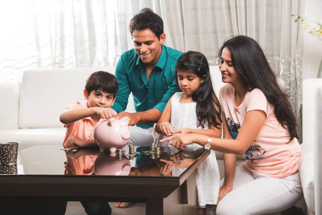 Family with two children and parents saving money together, placing coins in a piggy bank at home.