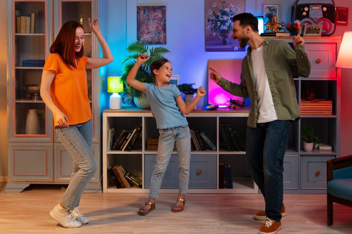 A family of three dancing joyfully in a colorful living room.