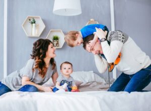 A joyful family playing together on a bed in a cozy room.