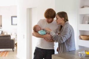 A young couple adoring their newborn baby at home.
